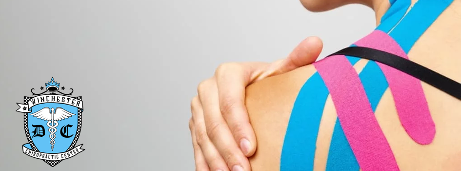 A woman has Kinesio Taping® throughout her shoulder which appears to be relieving tension.